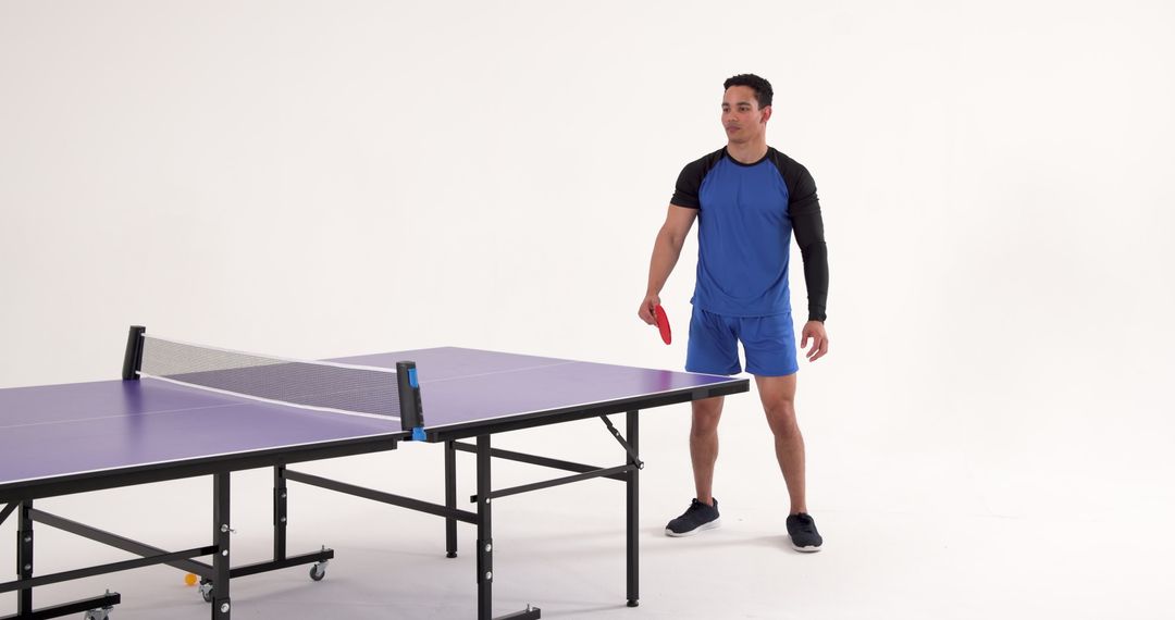Athletic Man Preparing for Table Tennis Game in Studio