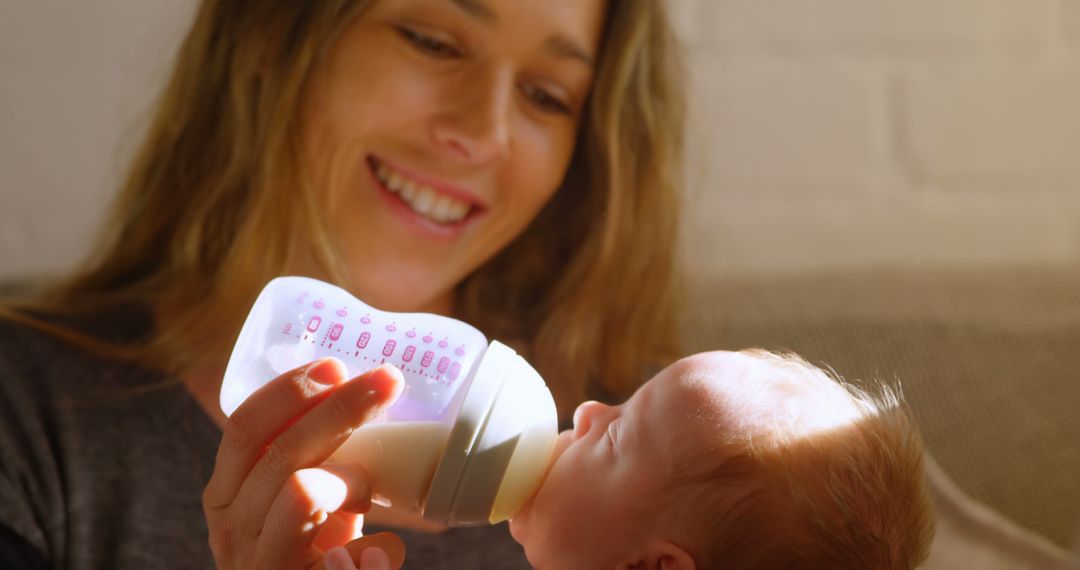 Smiling Mother Feeding Baby with Bottle at Home - Free Images, Stock Photos and Pictures on Pikwizard.com