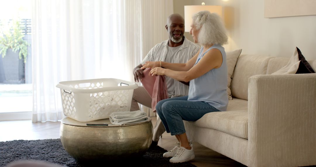 Senior Couple Folding Laundry Together in Cozy Living Room