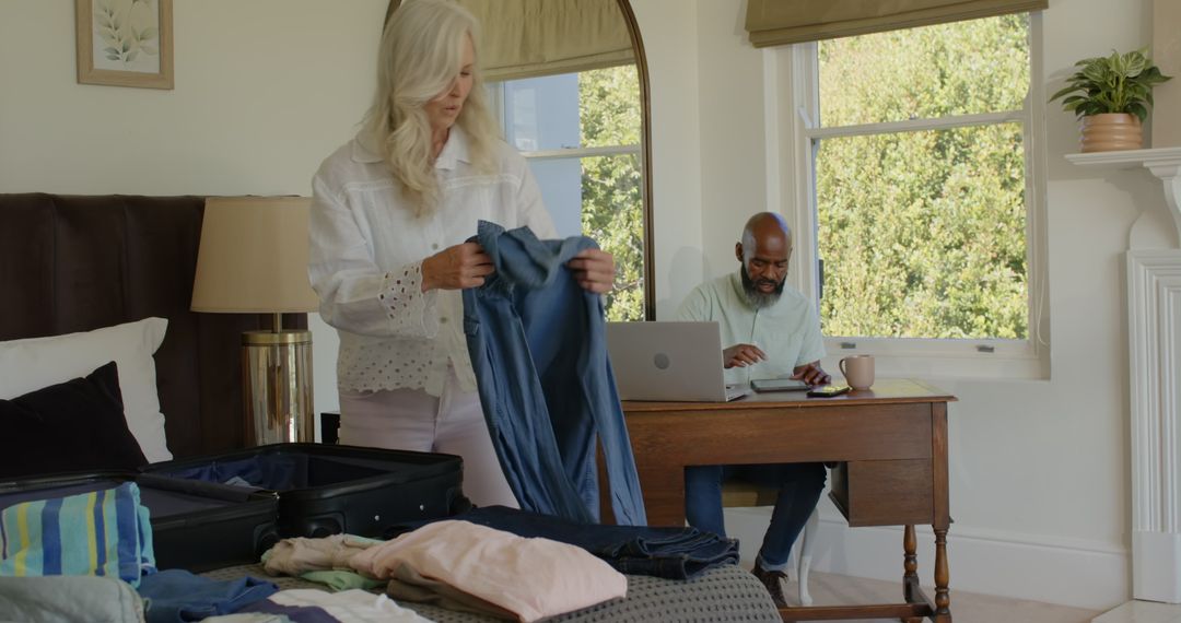 Couple Balancing Work and Packing for Upcoming Vacation