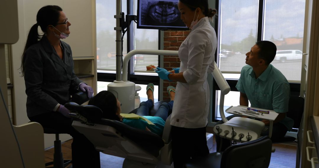 Dentist Explaining X-ray to Pediatric Patient with Parent Observing - Free Images, Stock Photos and Pictures on Pikwizard.com