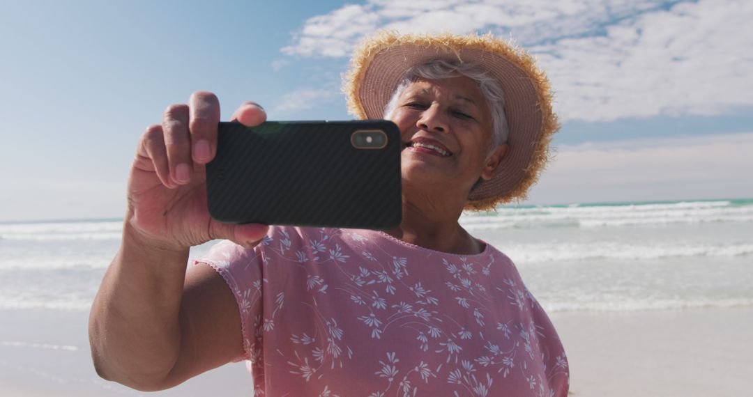 Biracial senior woman taking a selfie with a smartphone at the beach - Free Images, Stock Photos and Pictures on Pikwizard.com