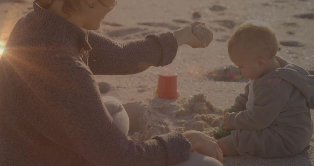 Mother and Child Creating Sandcastle on Sunny Beach