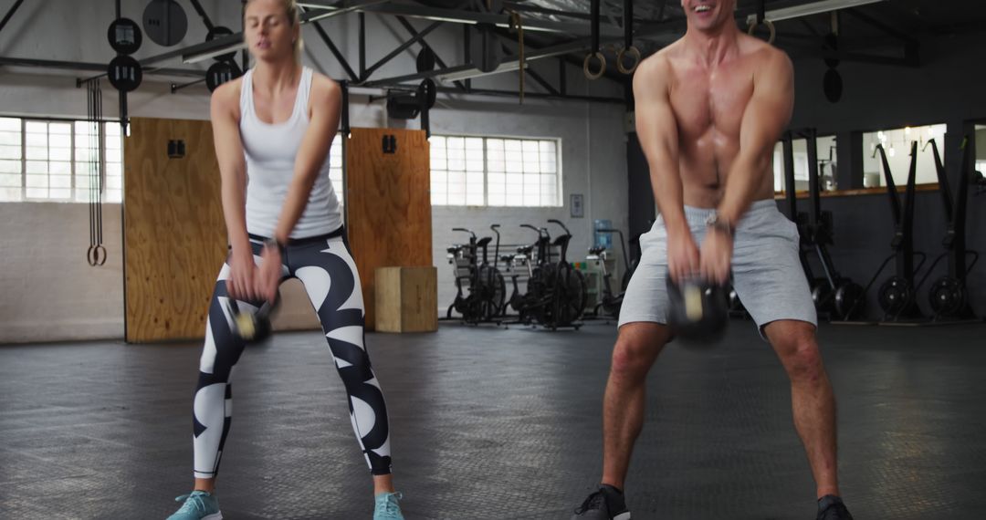 Man and Woman Performing Kettlebell Swings in Gym - Free Images, Stock Photos and Pictures on Pikwizard.com