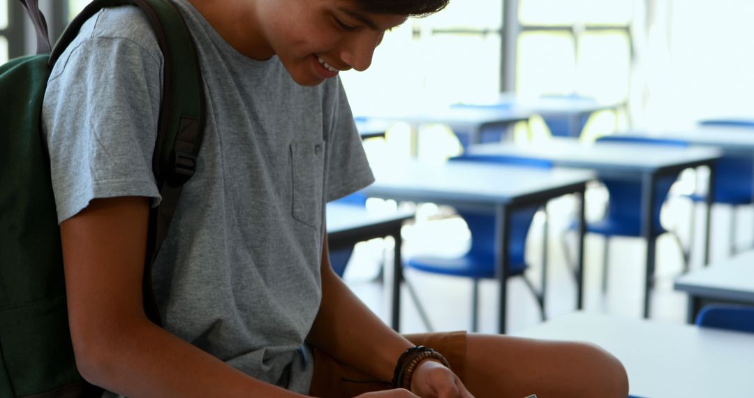 Focused Student Writing in Classroom with School Backpack