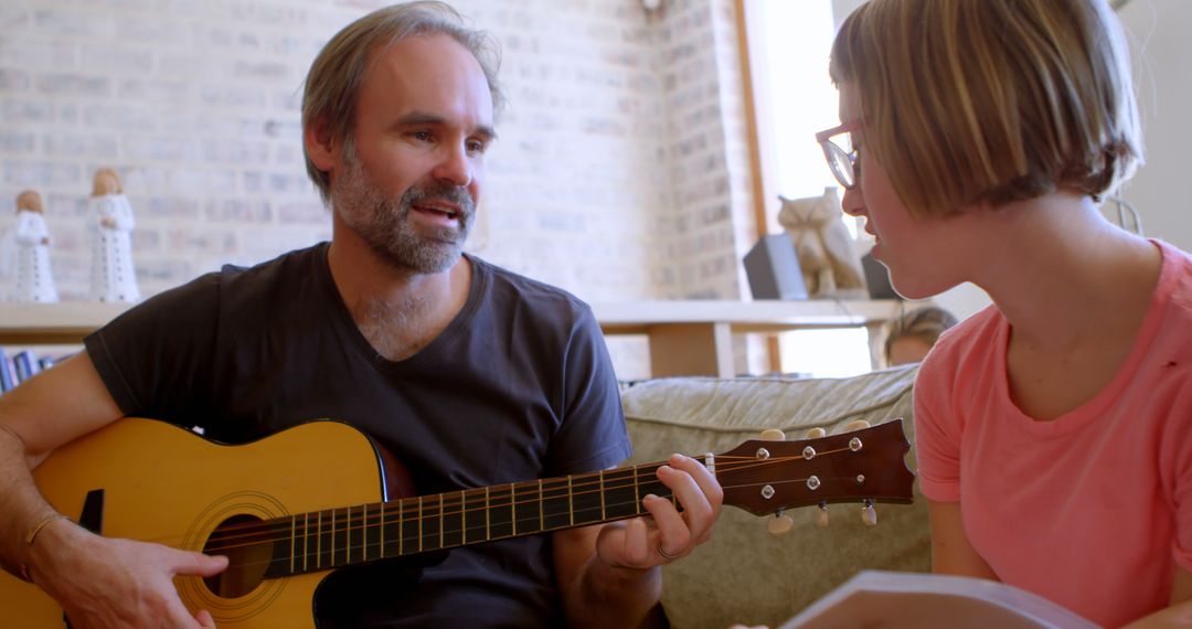 Man Teaching Guitar to Young Woman at Home - Free Images, Stock Photos and Pictures on Pikwizard.com