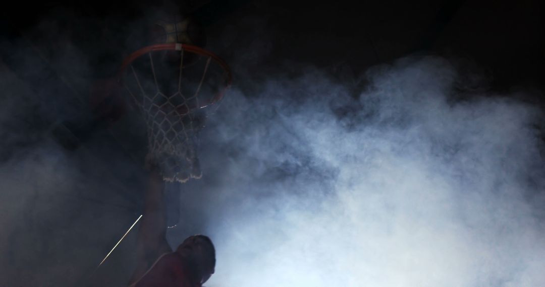 Basketball Player Dunking Through Hoop in Smoky Arena - Free Images, Stock Photos and Pictures on Pikwizard.com