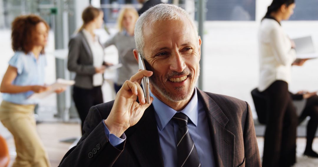 Businessman Talking on Phone in Busy Modern Office - Free Images, Stock Photos and Pictures on Pikwizard.com