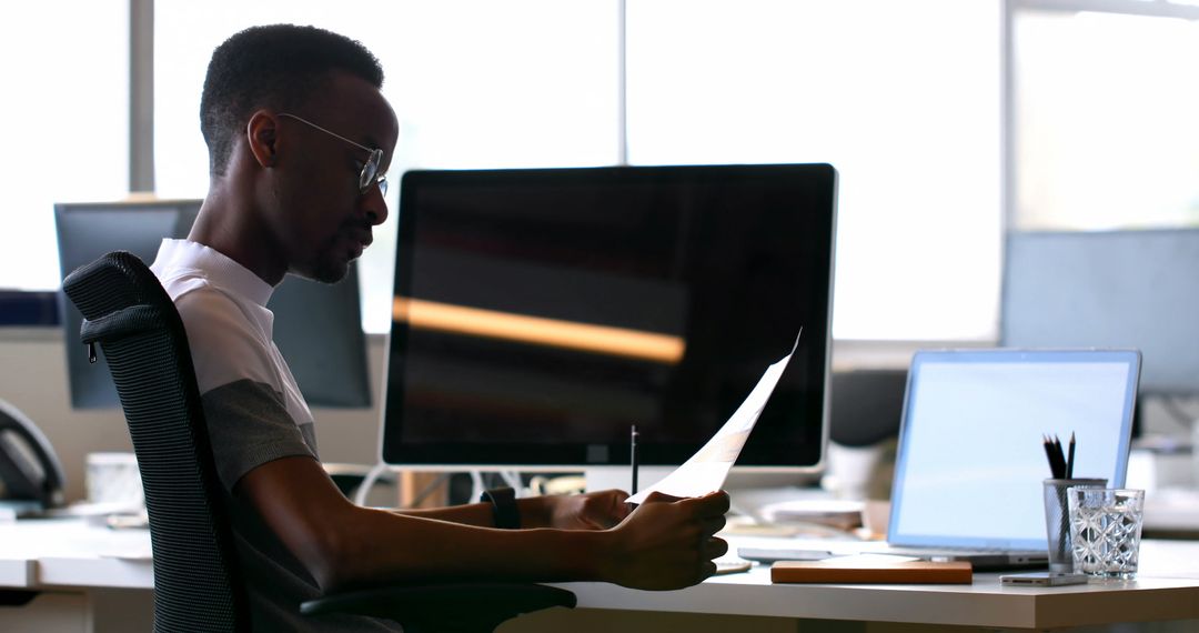 Focused Professional Analyzing Documents in Modern Office