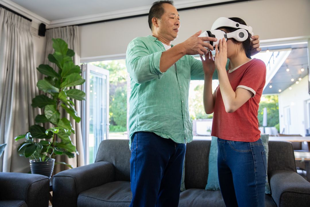 Father Assisting Daughter with Virtual Reality Headset at Home