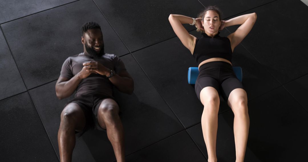 Diverse Athletes Performing Core Recovery on Foam Roller at Gym