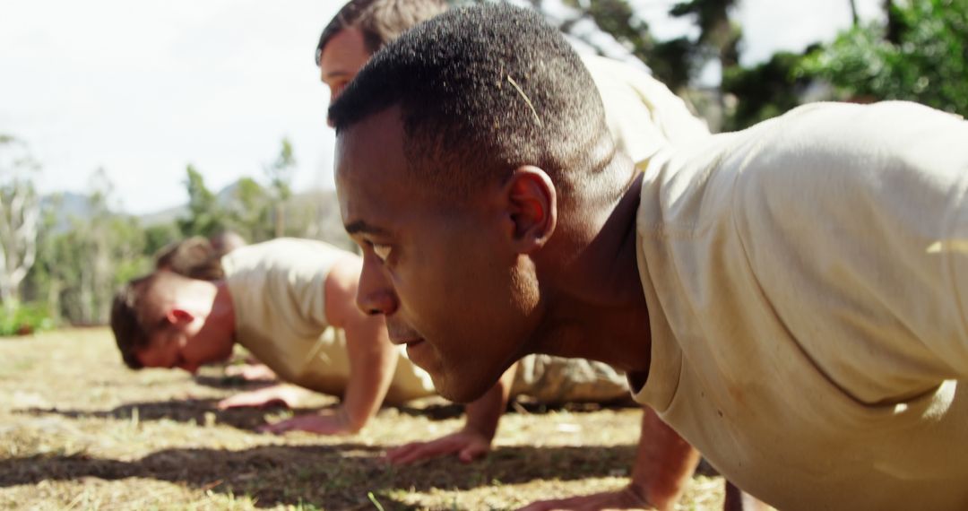Group Engaging in Intensive Outdoor Push-Up Exercise in Boot Camp