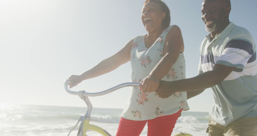 Happy Senior Couple Riding Bicycle Together on Beach - Free Images, Stock Photos and Pictures on Pikwizard.com