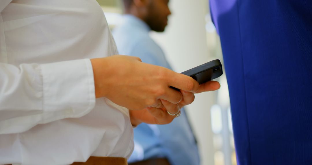 Businesswoman Using Smartphone in Queue at Seminar