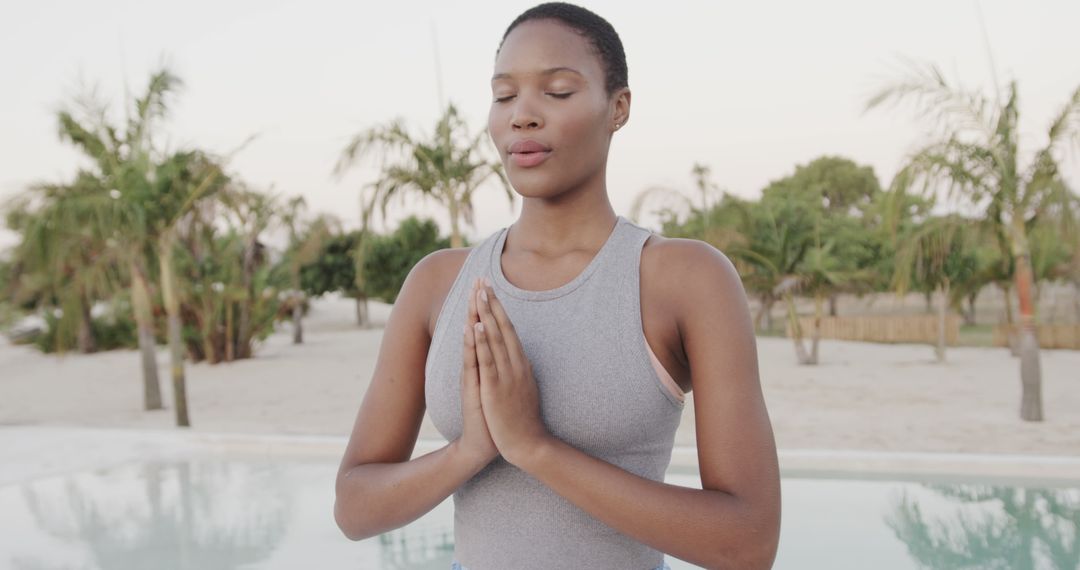 Serene Woman Meditating Outdoors Near Pool - Free Images, Stock Photos and Pictures on Pikwizard.com