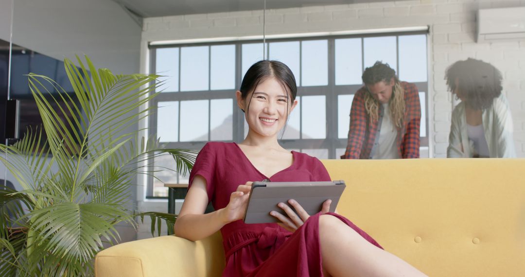 Smiling Asian Businesswoman Using Tablet in Modern Office Space