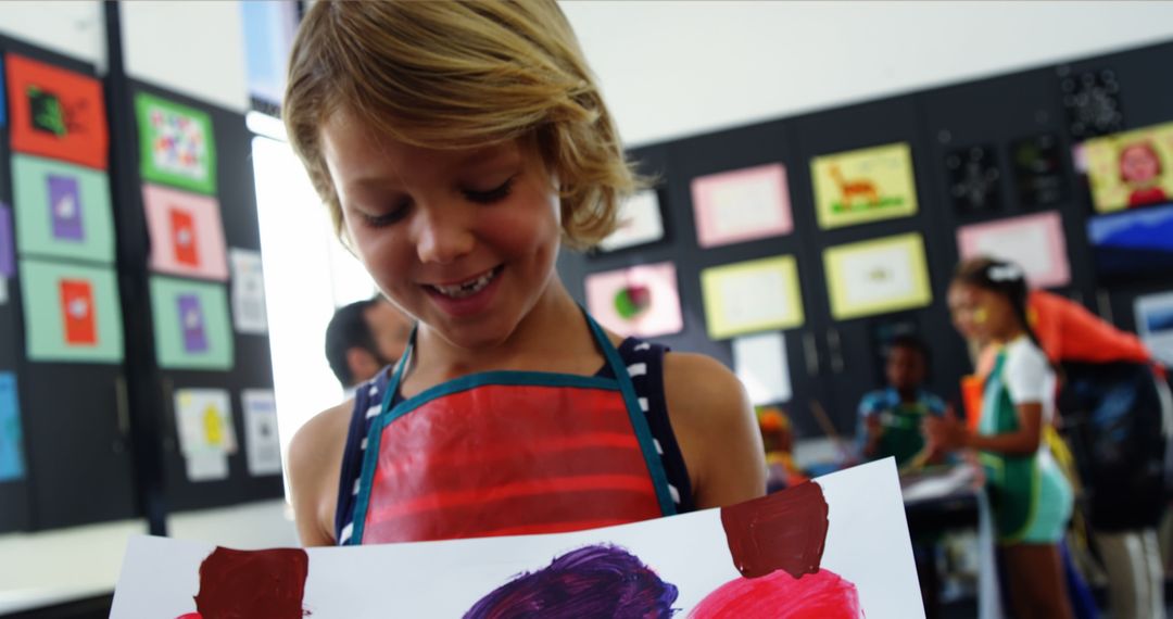 Young Child Proudly Displaying Artwork in Classroom - Free Images, Stock Photos and Pictures on Pikwizard.com