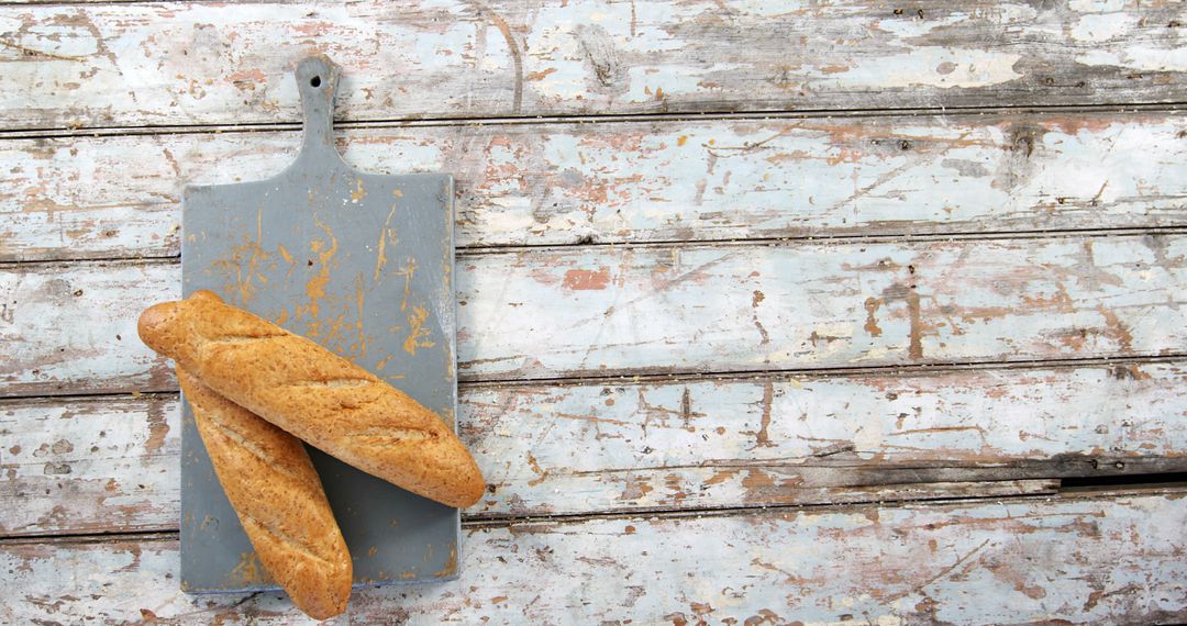 Rustic Wooden Background with Freshly Baked Baguettes on Cutting Board - Free Images, Stock Photos and Pictures on Pikwizard.com