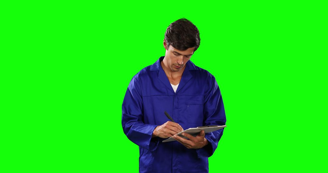 Warehouse Worker in Blue Uniform Writing on Clipboard Isolated on Green Screen - Free Images, Stock Photos and Pictures on Pikwizard.com