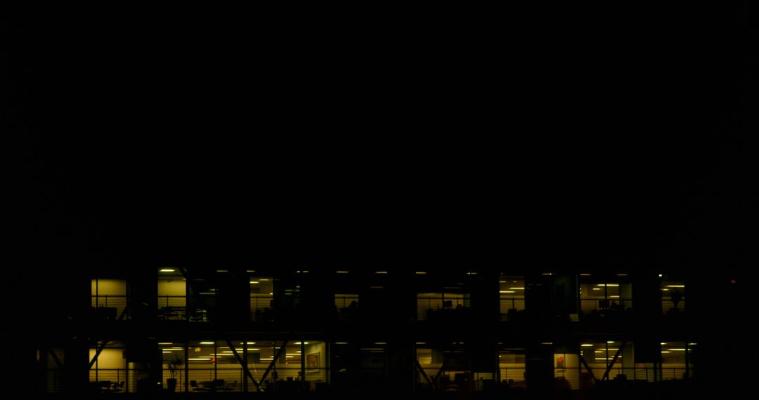 Night View of Illuminated Office Building with Window Silhouettes - Free Images, Stock Photos and Pictures on Pikwizard.com