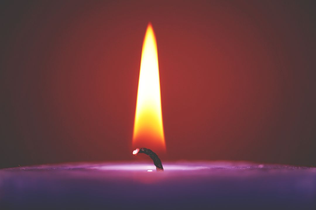 Close-Up of a Burning Candle with Flickering Flame