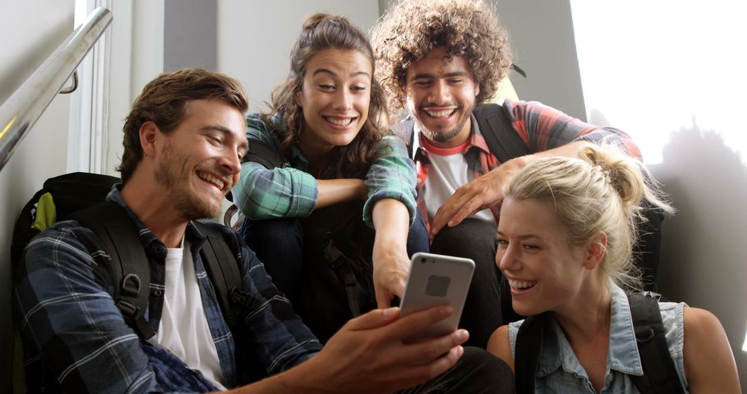 Group of Happy Students Laughing and Looking at Smartphone Together - Free Images, Stock Photos and Pictures on Pikwizard.com