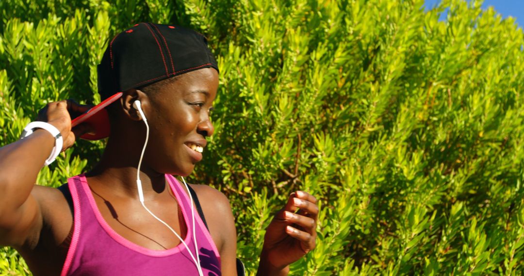 Woman Enjoying Outdoor Workout with Music, Wearing Cap and Headphones - Free Images, Stock Photos and Pictures on Pikwizard.com