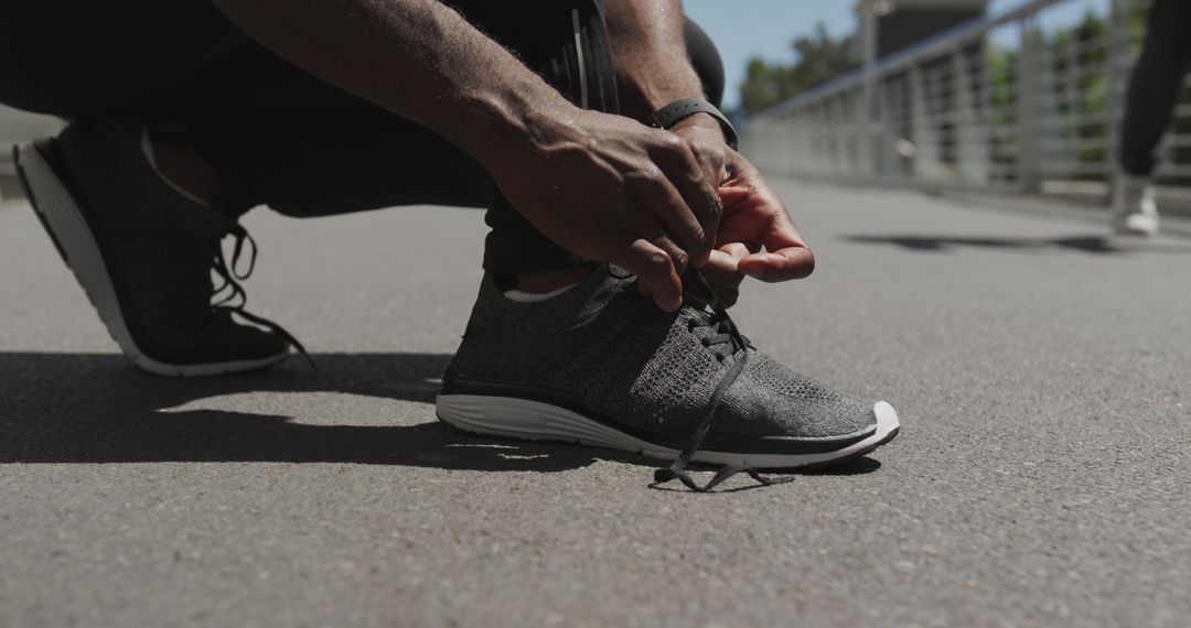 Athlete Tying Running Shoe on Urban Pathway - Free Images, Stock Photos and Pictures on Pikwizard.com