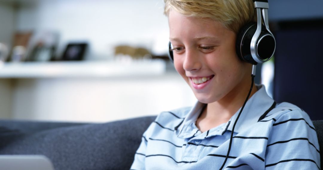 Smiling Boy Relaxing with Headphones and Tablet
