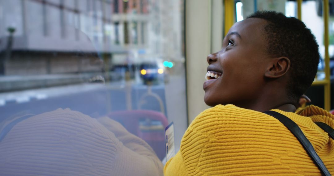 Happy African American Woman Enjoying City View Through Window - Free Images, Stock Photos and Pictures on Pikwizard.com