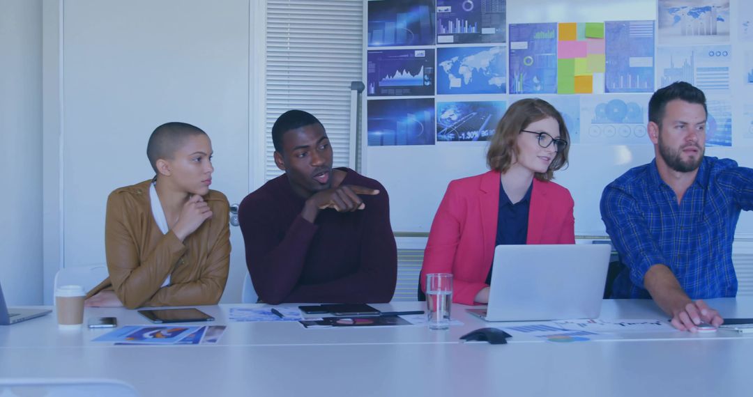 Diverse Team Analyzing Data Charts in Conference Room