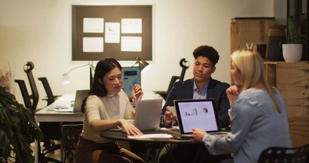 Diverse Coworkers Collaborating on Projects at Night