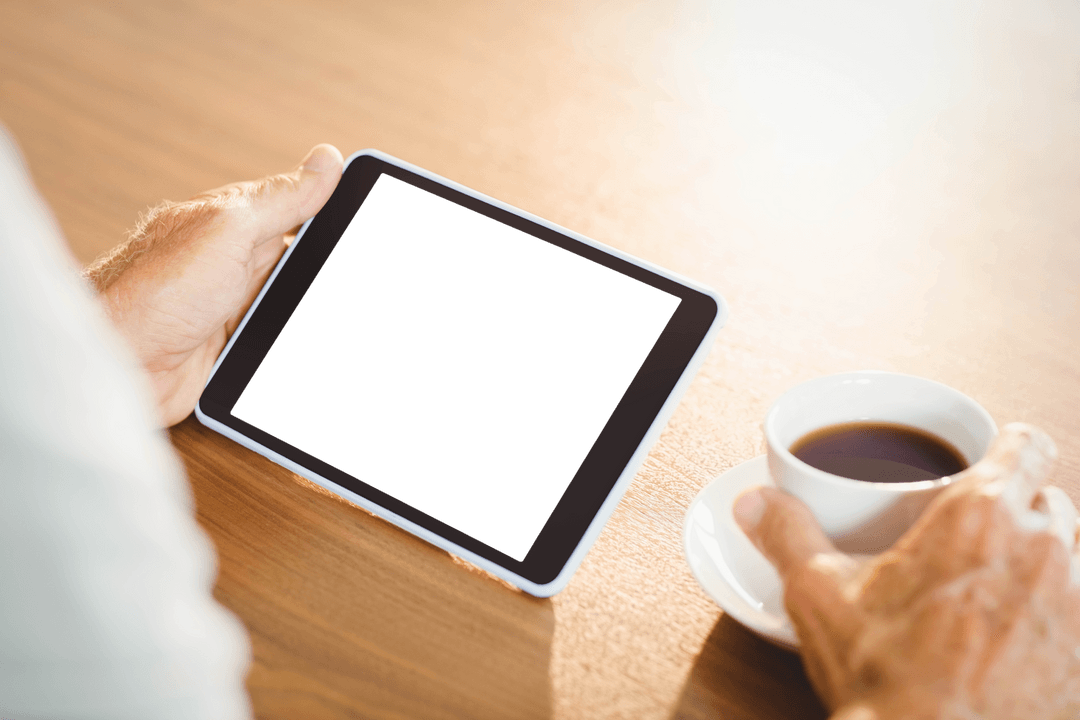 Transparent Tablet Use by Elderly Man with Coffee Enjoyment