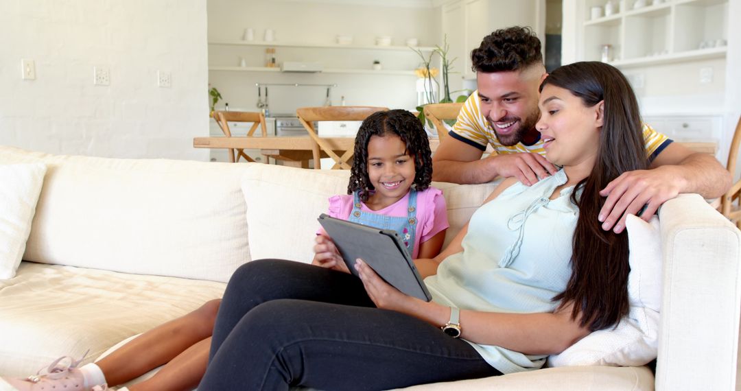 Happy Family Using Tablet on Bright Sofa in Modern Living Room