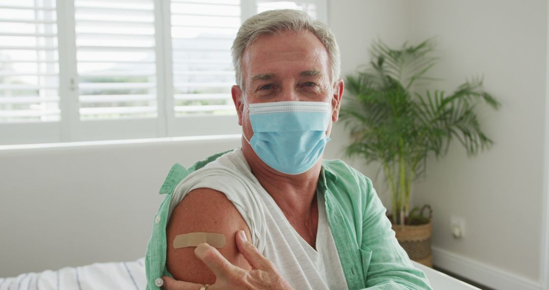 Caucasian senior man wearing face mask and plaster after vaccination - Free Images, Stock Photos and Pictures on Pikwizard.com