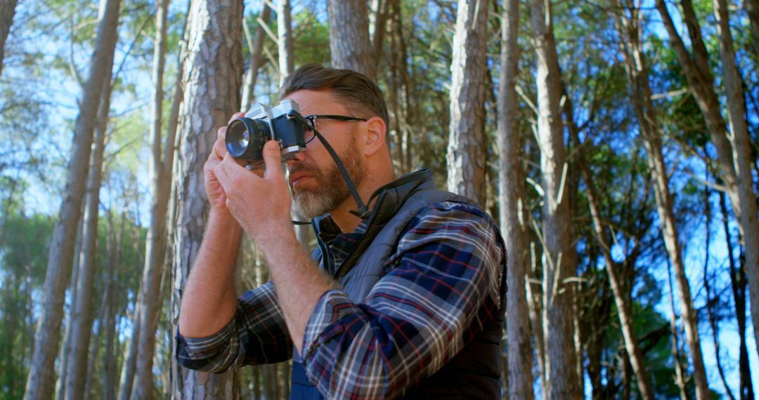 Adult Male Photographer Capturing Outdoor Forest Scene - Free Images, Stock Photos and Pictures on Pikwizard.com