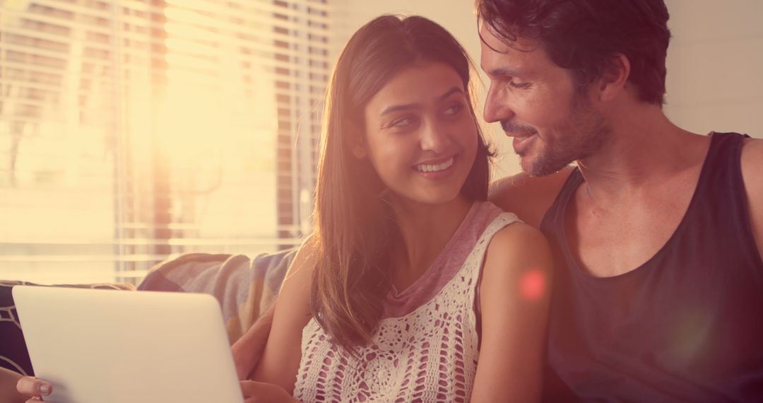 Happy Couple Browsing Internet on Couch at Home