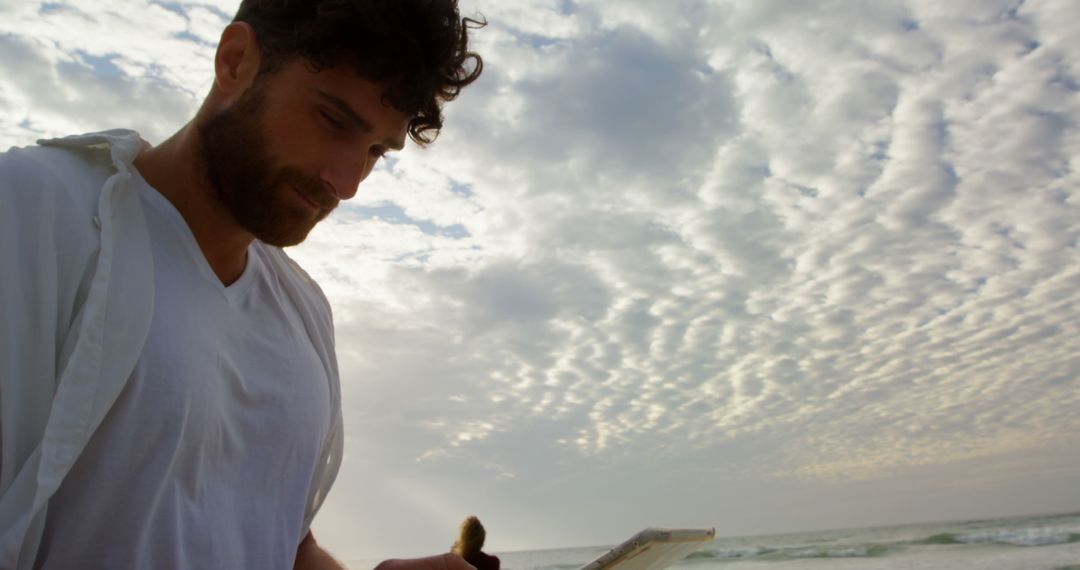 Young Man Reading Book on Beach at Sunset - Free Images, Stock Photos and Pictures on Pikwizard.com