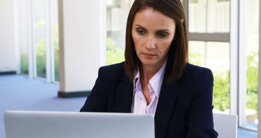 Professional Woman Working on Laptop in Modern Office - Free Images, Stock Photos and Pictures on Pikwizard.com