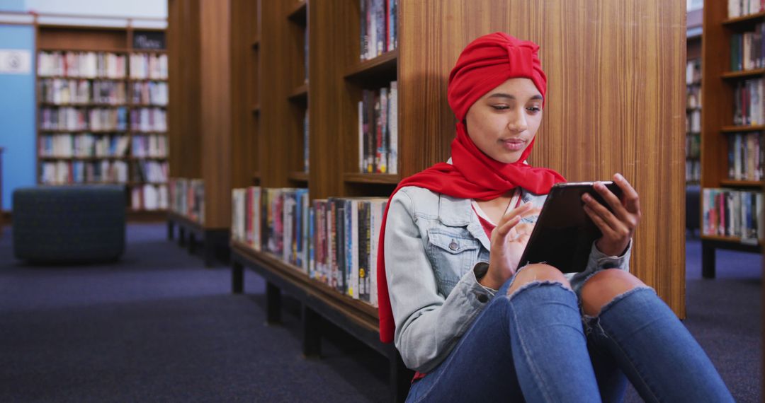 Young Woman Reading Digital Tablet in Library - Free Images, Stock Photos and Pictures on Pikwizard.com