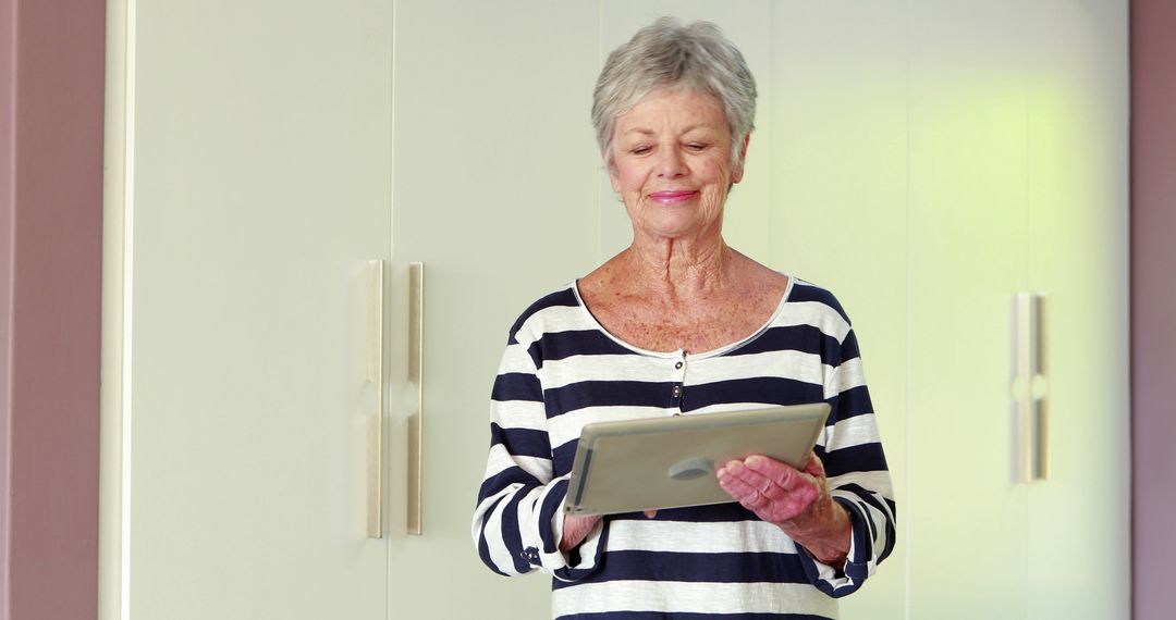 Senior Woman Using Tablet in Cozy Home Living Room - Free Images, Stock Photos and Pictures on Pikwizard.com