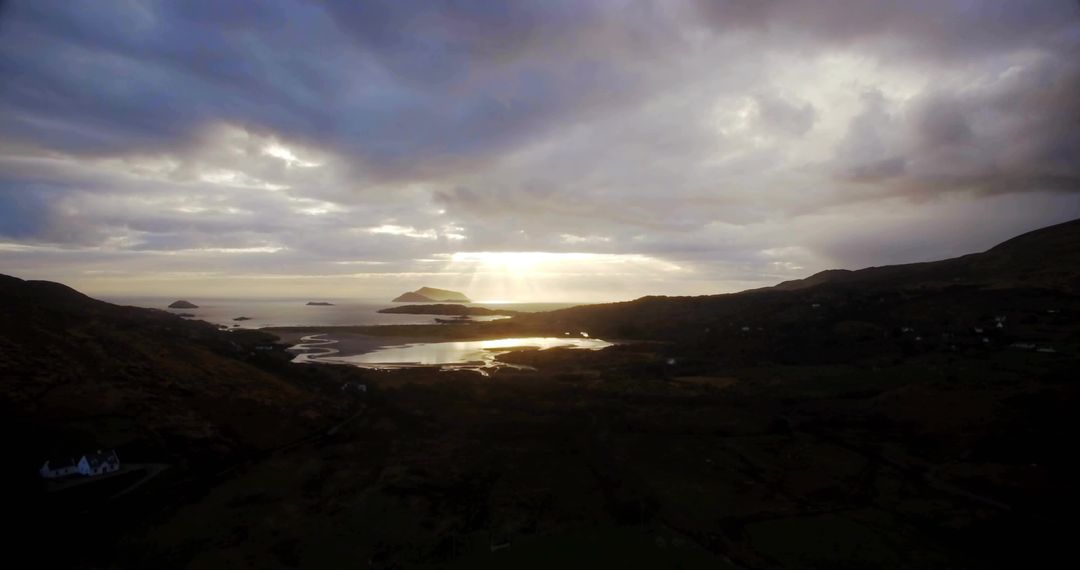 Sunset Rays Over Tranquil Coastal Channel with Distant Islands