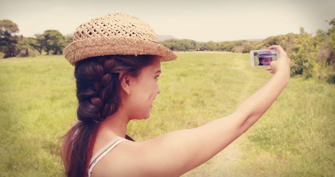 Young Woman Taking Selfie in Field Wearing Straw Hat - Free Images, Stock Photos and Pictures on Pikwizard.com