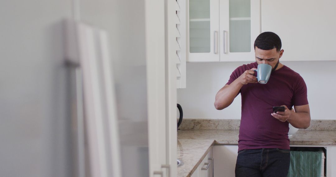 Man Enjoying Morning Coffee Texting in Modern Kitchen - Free Images, Stock Photos and Pictures on Pikwizard.com