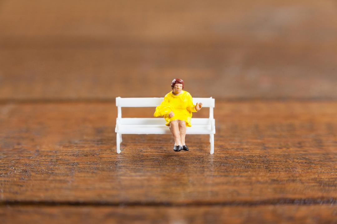 Miniature woman sitting on a bench - Free Images, Stock Photos and Pictures on Pikwizard.com