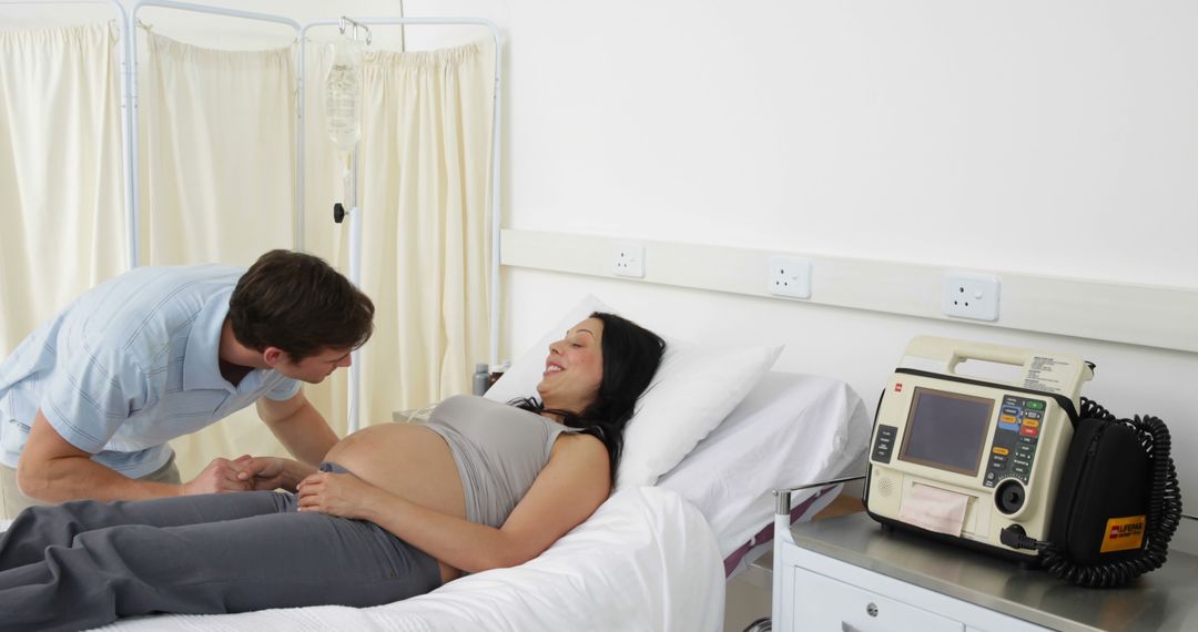 Father Listening to Pregnant Woman's Belly in Hospital Room - Free Images, Stock Photos and Pictures on Pikwizard.com