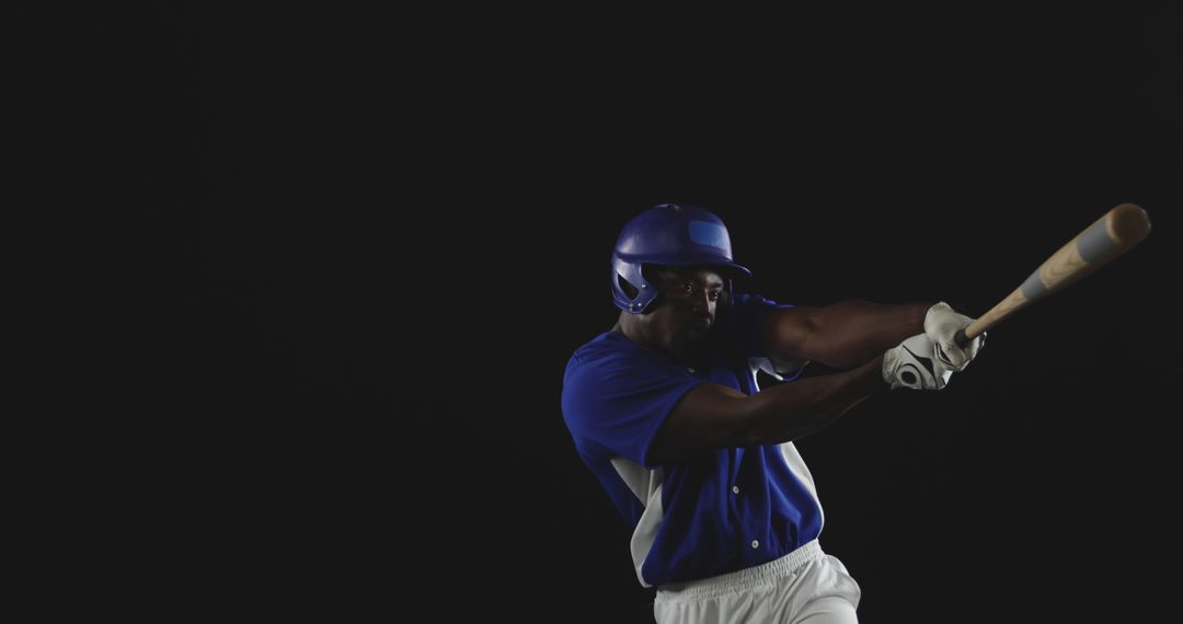 Athlete in Blue Uniform Batting in Low Light - Free Images, Stock Photos and Pictures on Pikwizard.com