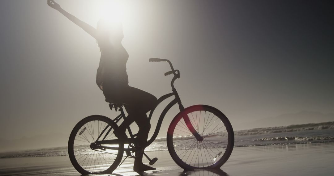 Silhouette of Happy Woman Riding Bicycle on Dusk Beach - Free Images, Stock Photos and Pictures on Pikwizard.com