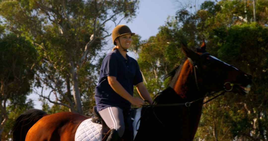 A young Caucasian woman enjoys horseback riding in a sunny outdoor setting, with copy space - Free Images, Stock Photos and Pictures on Pikwizard.com