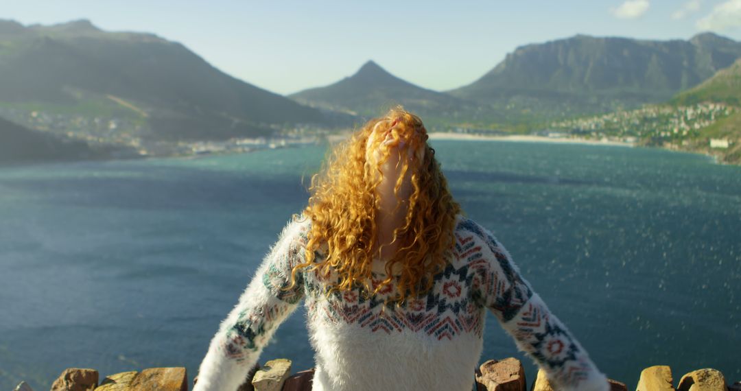 Red-haired woman enjoying ocean breeze atop scenic hill - Free Images, Stock Photos and Pictures on Pikwizard.com